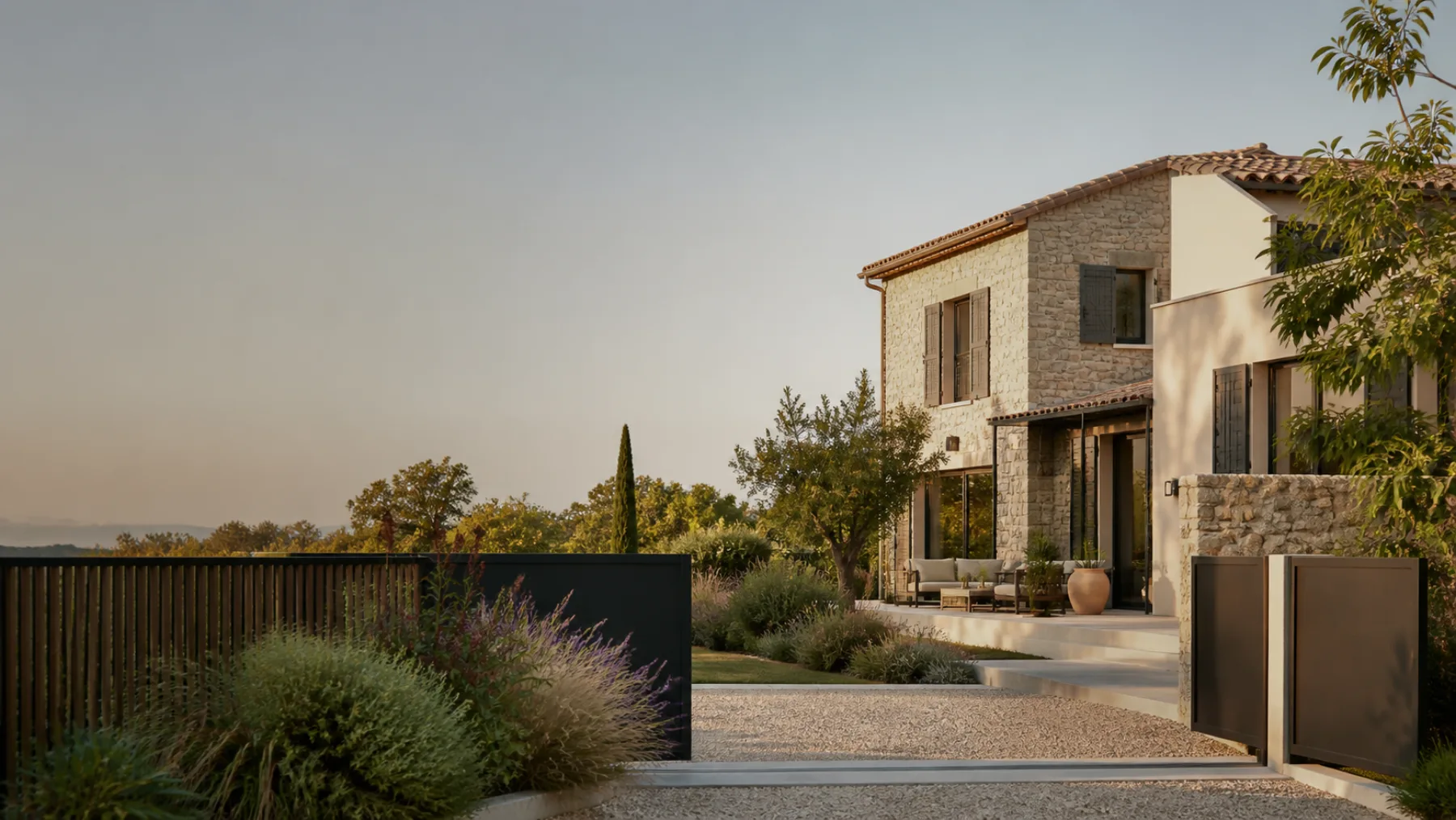 Clôture contemporaine et maison en pierre